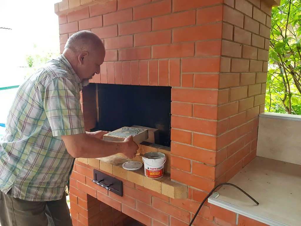 Печник кладет кирпич